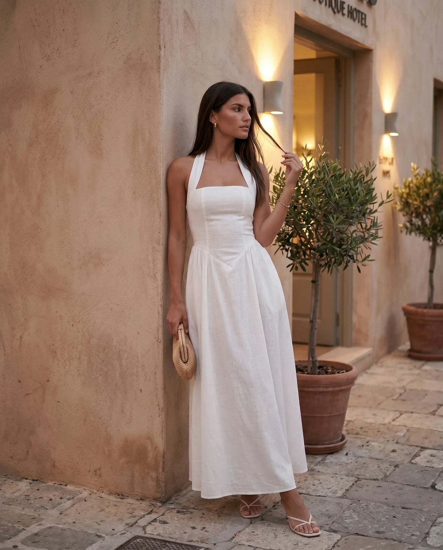Aurora basque waist halter maxi dress with a halter neckline, open back, defined basque waist, and flowing A-line skirt in smooth fabric, ideal for weddings, formal events, and evening occasions.