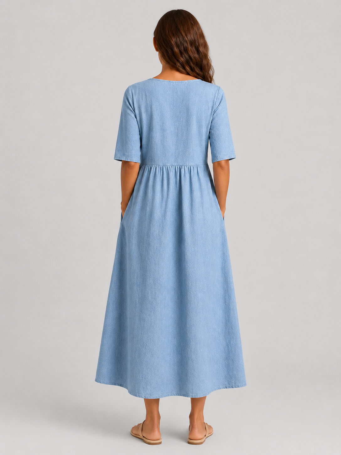 Woman wearing a relaxed-fit linen blend midi dress with a soft drape and breathable fabric, styled for effortless daytime elegance.