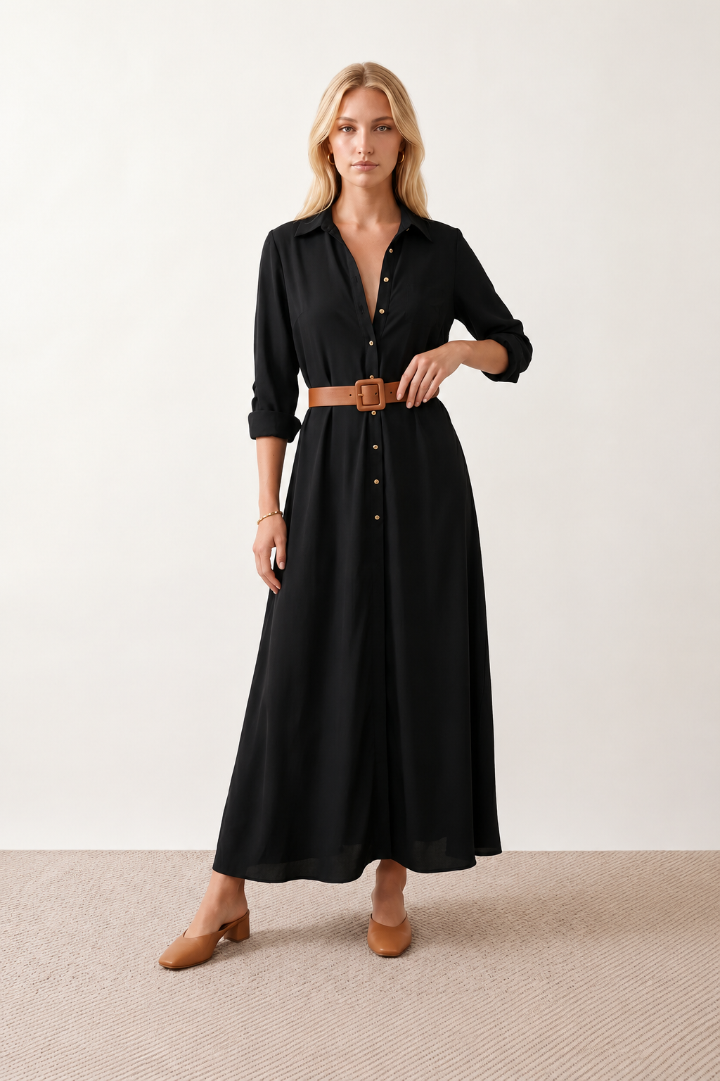 Woman wearing the Julieta Button Front Maxi Dress with a deep V-neck, shirt collar, button-front bodice, long sleeves, belted waist with a square-buckle belt, asymmetric pleated hip drape, and flowing maxi-length skirt.