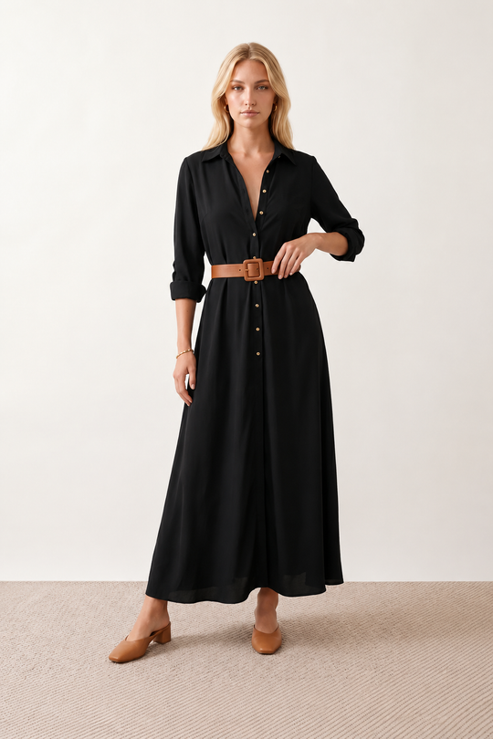 Woman wearing the Julieta Button Front Maxi Dress with a deep V-neck, shirt collar, button-front bodice, long sleeves, belted waist with a square-buckle belt, asymmetric pleated hip drape, and flowing maxi-length skirt.