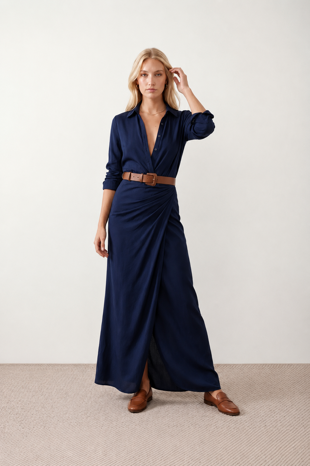Woman wearing the Julieta Button Front Maxi Dress with a deep V-neck, shirt collar, button-front bodice, long sleeves, belted waist with a square-buckle belt, asymmetric pleated hip drape, and flowing maxi-length skirt.