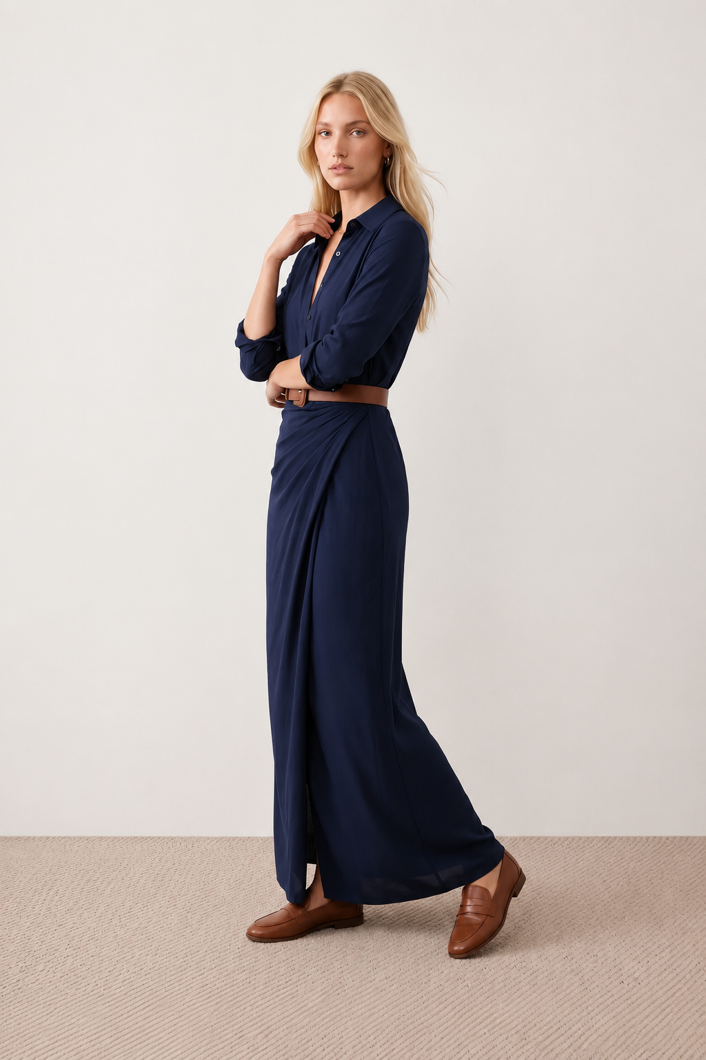 Woman wearing the Julieta Button Front Maxi Dress with a deep V-neck, shirt collar, button-front bodice, long sleeves, belted waist with a square-buckle belt, asymmetric pleated hip drape, and flowing maxi-length skirt.