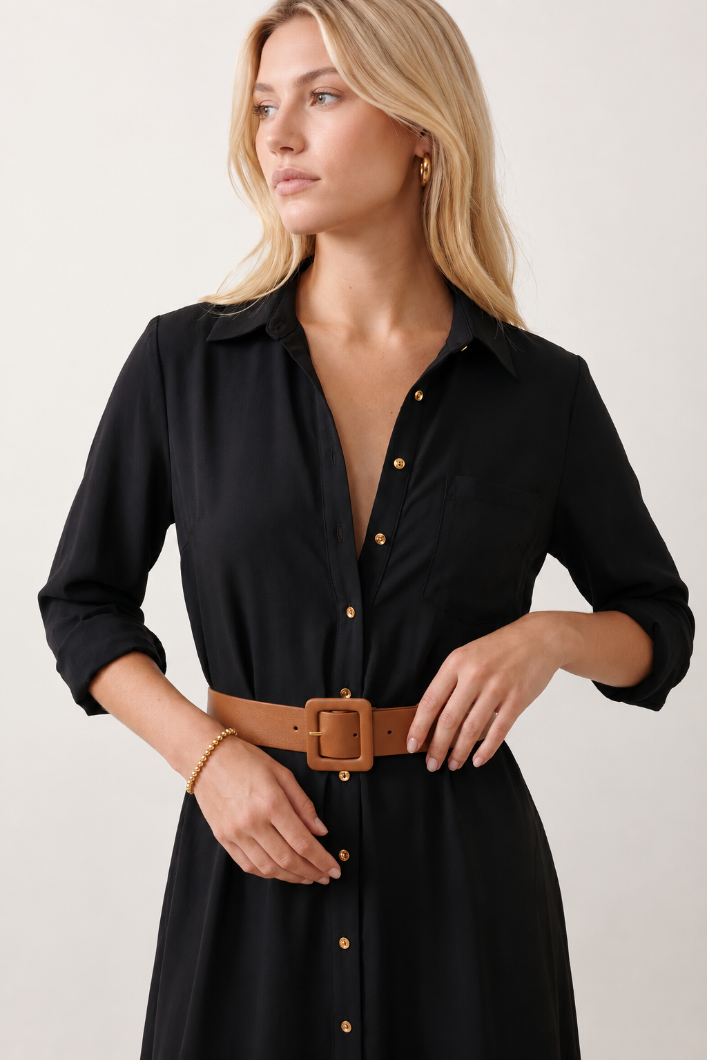 Woman wearing the Julieta Button Front Maxi Dress with a deep V-neck, shirt collar, button-front bodice, long sleeves, belted waist with a square-buckle belt, asymmetric pleated hip drape, and flowing maxi-length skirt.