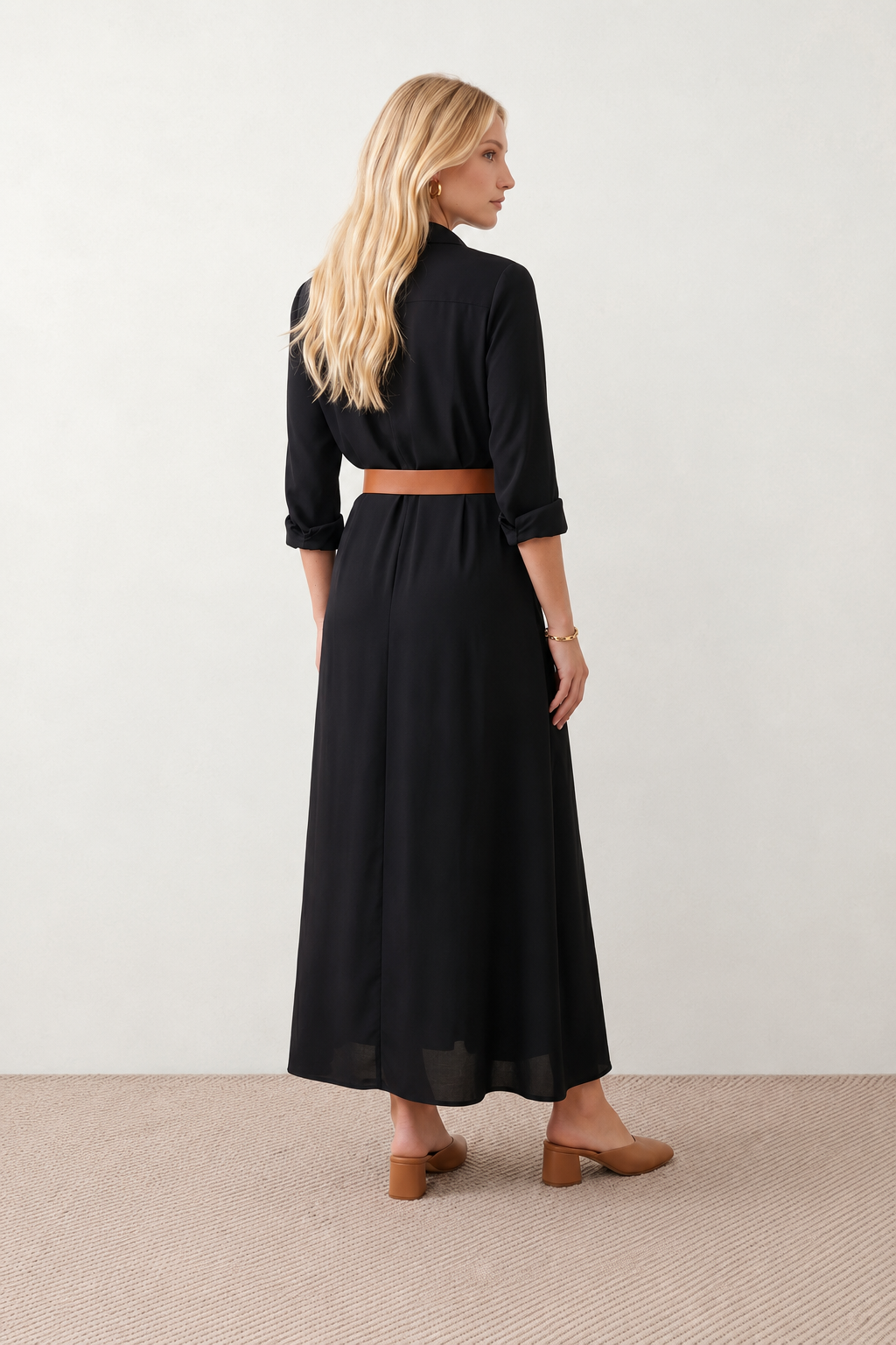 Woman wearing the Julieta Button Front Maxi Dress with a deep V-neck, shirt collar, button-front bodice, long sleeves, belted waist with a square-buckle belt, asymmetric pleated hip drape, and flowing maxi-length skirt.