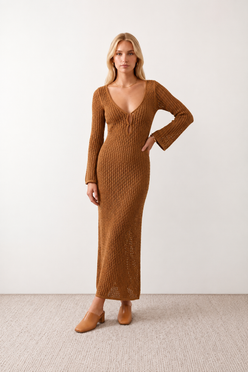 Woman wearing the Calixta Crochet Plunge Neck Maxi Dress in an elegant open-knit crochet design with a deep plunge V-neck, keyhole detail, long flared sleeves, low open back and fitted floor-length silhouette, ideal for beach holidays, festivals and summer occasion wear.