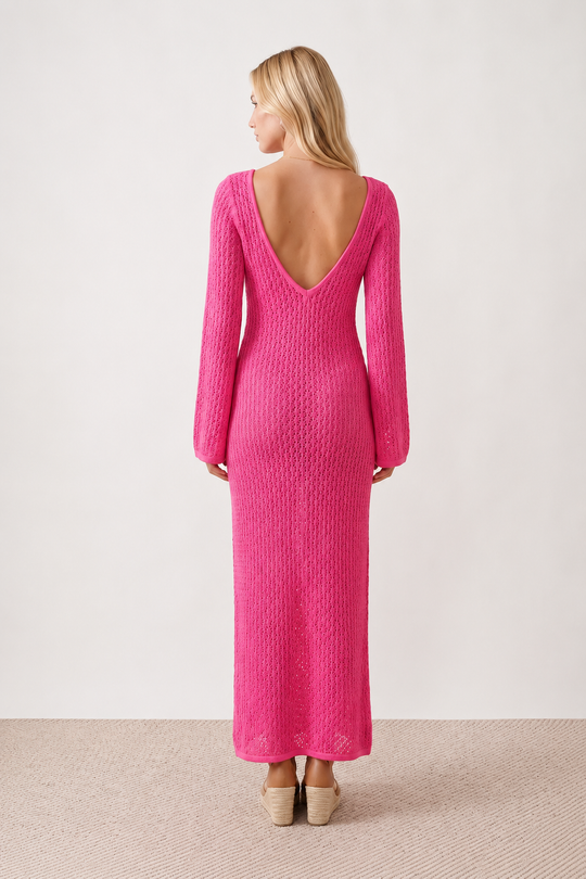 Woman wearing the Calixta Crochet Plunge Neck Maxi Dress in an elegant open-knit crochet design with a deep plunge V-neck, keyhole detail, long flared sleeves, low open back and fitted floor-length silhouette, ideal for beach holidays, festivals and summer occasion wear.