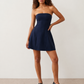 Woman wearing the Camilla Strapless Pleated Mini Dress featuring a structured strapless square neckline, fitted bodice, softly pleated A-line mini skirt, natural waist, and concealed back zip, styled for weddings, cocktail parties, race days, and special occasions.