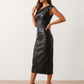 Woman wearing the Celia Faux Leather Glossy Midi Dress in high-shine faux leather, featuring an asymmetric off-the-shoulder draped neckline, fitted pencil silhouette, ruched waist, low-back design with concealed zip fastening, back slit, and elegant midi length, styled for cocktail parties and evening occasions.