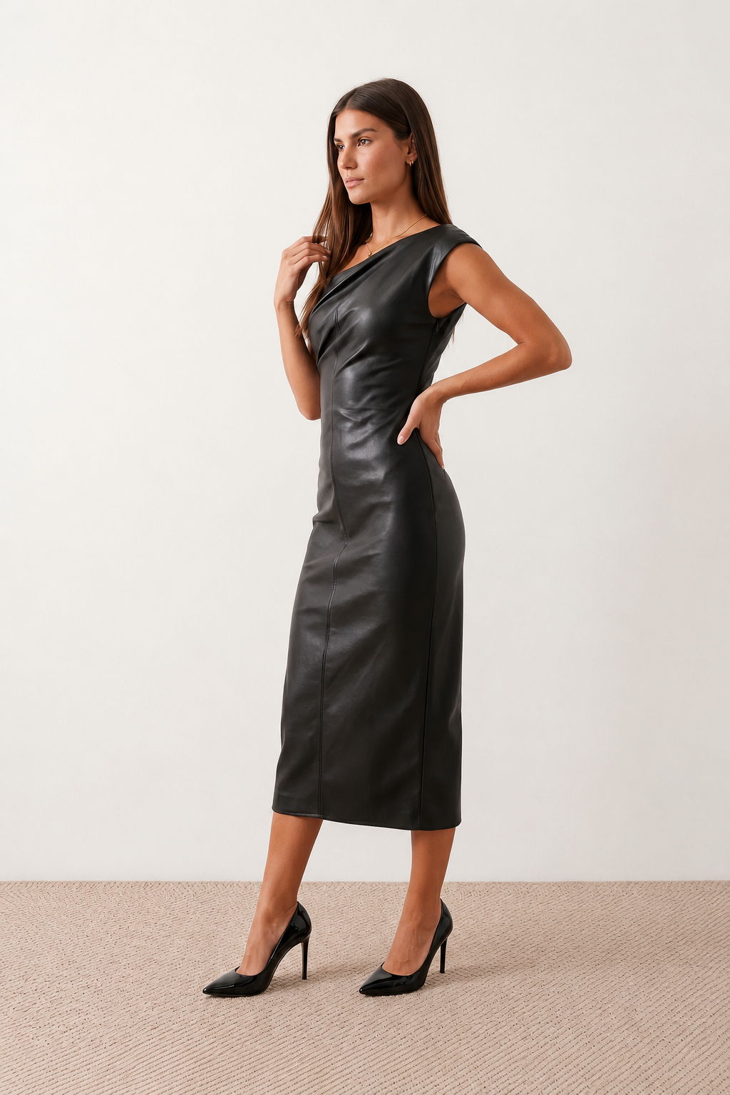 Woman wearing the Celia Faux Leather Glossy Midi Dress in high-shine faux leather, featuring an asymmetric off-the-shoulder draped neckline, fitted pencil silhouette, ruched waist, low-back design with concealed zip fastening, back slit, and elegant midi length, styled for cocktail parties and evening occasions.