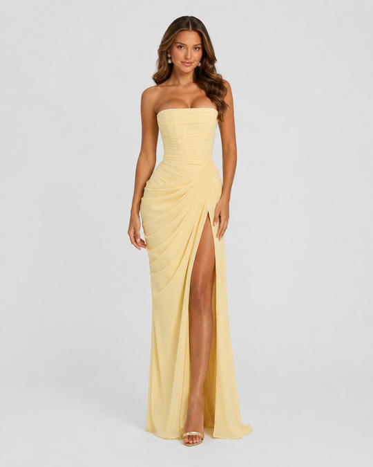 Women's strapless corset maxi dress with asymmetric draped skirt, thigh-high split, fitted bodice and flowing silhouette for elegant evening occasions.