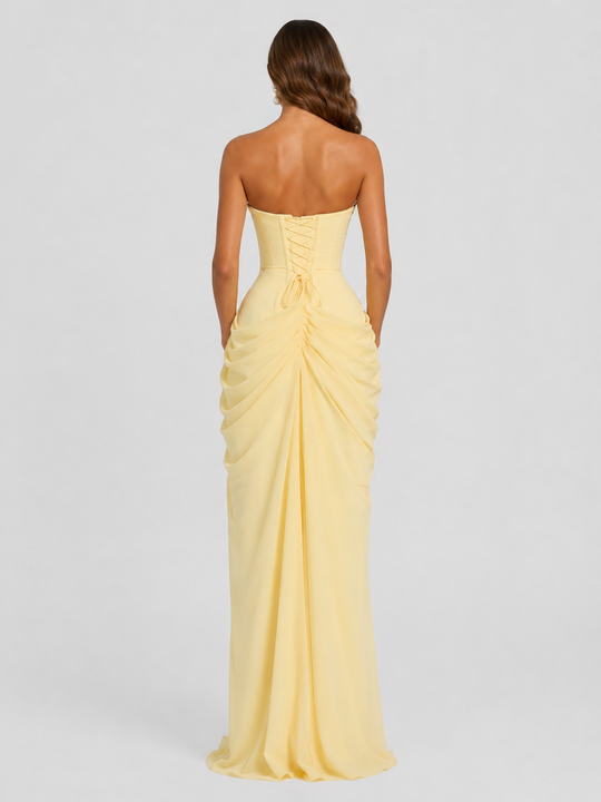 Women's strapless corset maxi dress with asymmetric draped skirt, thigh-high split, fitted bodice and flowing silhouette for elegant evening occasions.
