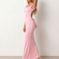 Woman wearing the Aline Cowl Neck Backless Maxi Dress in a floor-length fitted silhouette with a draped cowl neckline, elegant open back, oversized satin bow tie detail, sleeveless design, and smooth woven fabric, ideal for weddings, black-tie events, galas, and evening occasions.