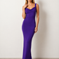 Woman wearing the Aline Cowl Neck Backless Maxi Dress in a floor-length fitted silhouette with a draped cowl neckline, elegant open back, oversized satin bow tie detail, sleeveless design, and smooth woven fabric, ideal for weddings, black-tie events, galas, and evening occasions.