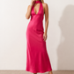 Aleena cowl neck halter maxi dress with a deep draped neckline, fitted halter strap, open back with tie-neck closure, sleeveless column silhouette, and floor-length straight hem in a smooth, elegant finish.