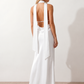Aleena cowl neck halter maxi dress with a deep draped neckline, fitted halter strap, open back with tie-neck closure, sleeveless column silhouette, and floor-length straight hem in a smooth, elegant finish.
