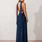 Aleena cowl neck halter maxi dress with a deep draped neckline, fitted halter strap, open back with tie-neck closure, sleeveless column silhouette, and floor-length straight hem in a smooth, elegant finish.
