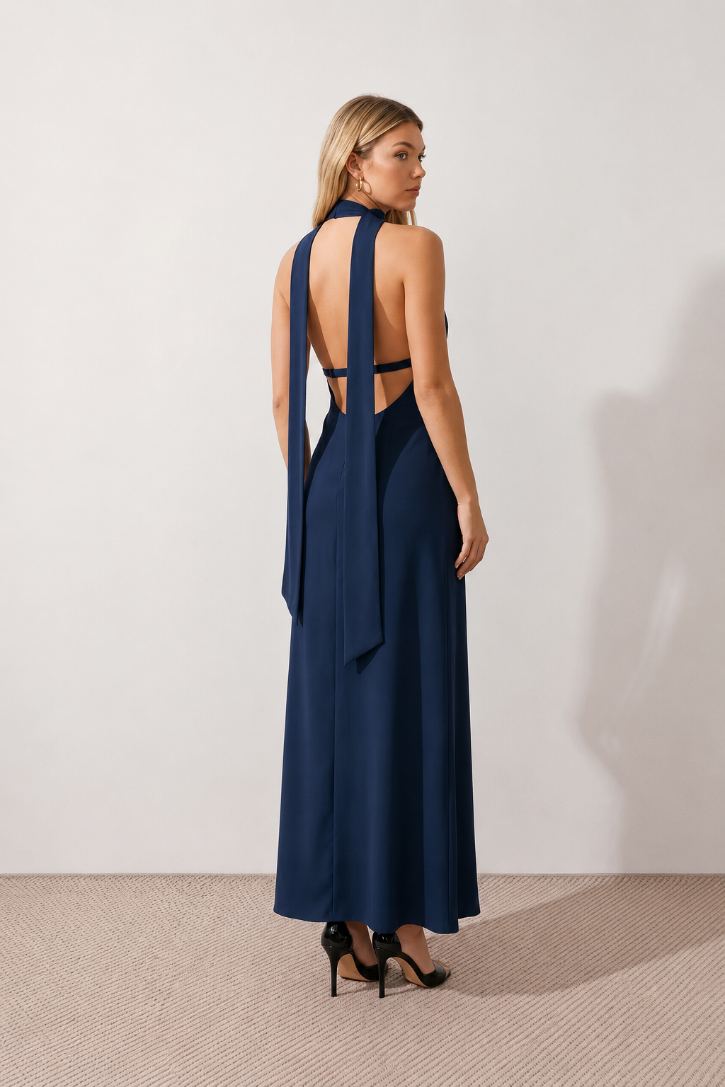 Aleena cowl neck halter maxi dress with a deep draped neckline, fitted halter strap, open back with tie-neck closure, sleeveless column silhouette, and floor-length straight hem in a smooth, elegant finish.