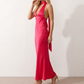 Aleena cowl neck halter maxi dress with a deep draped neckline, fitted halter strap, open back with tie-neck closure, sleeveless column silhouette, and floor-length straight hem in a smooth, elegant finish.