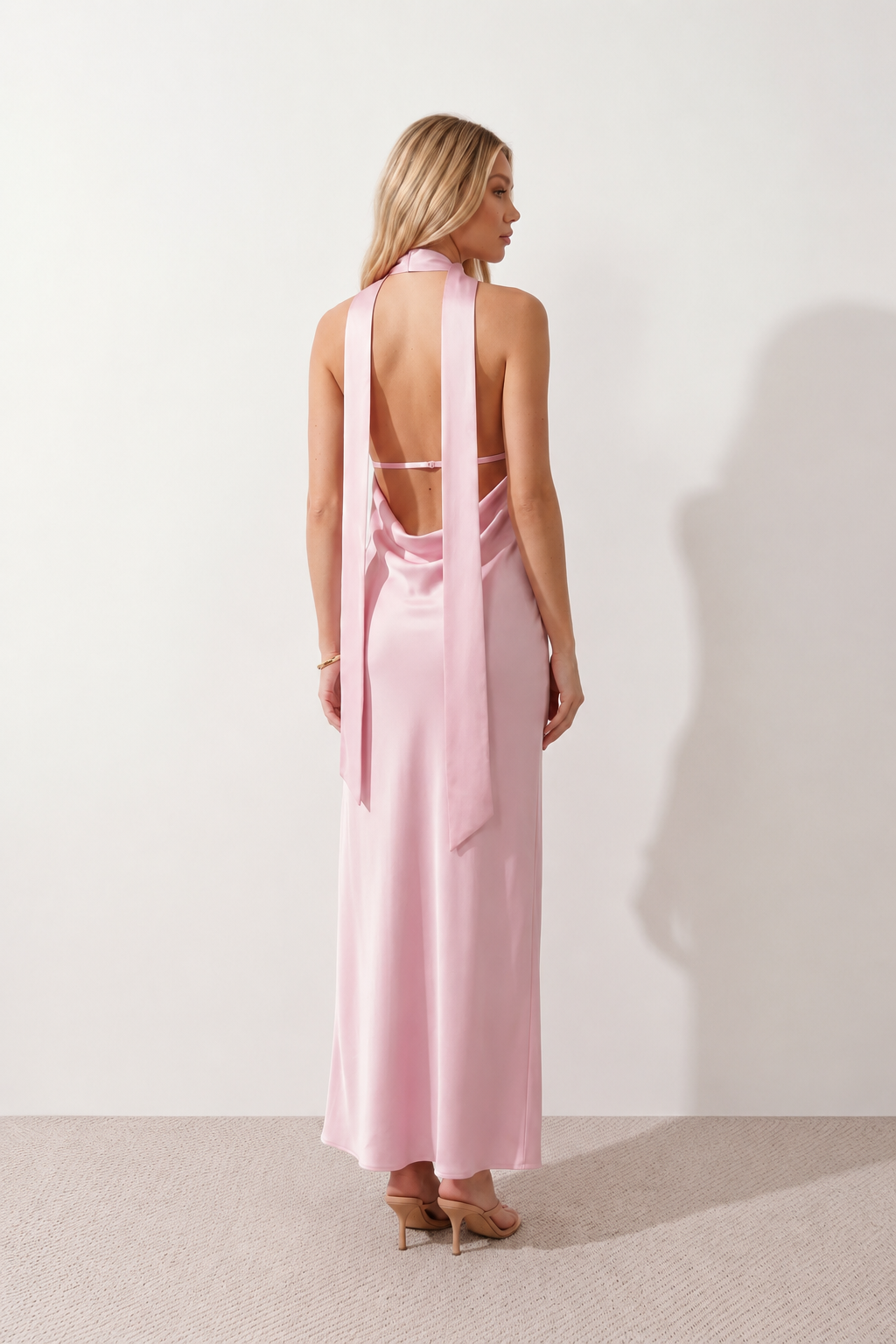 Aleena cowl neck halter maxi dress with a deep draped neckline, fitted halter strap, open back with tie-neck closure, sleeveless column silhouette, and floor-length straight hem in a smooth, elegant finish.