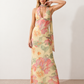 Aleena cowl neck halter maxi dress with a deep draped neckline, fitted halter strap, open back with tie-neck closure, sleeveless column silhouette, and floor-length straight hem in a smooth, elegant finish.