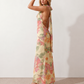 Aleena cowl neck halter maxi dress with a deep draped neckline, fitted halter strap, open back with tie-neck closure, sleeveless column silhouette, and floor-length straight hem in a smooth, elegant finish.