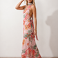Aleena cowl neck halter maxi dress with a deep draped neckline, fitted halter strap, open back with tie-neck closure, sleeveless column silhouette, and floor-length straight hem in a smooth, elegant finish.