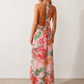 Aleena cowl neck halter maxi dress with a deep draped neckline, fitted halter strap, open back with tie-neck closure, sleeveless column silhouette, and floor-length straight hem in a smooth, elegant finish.
