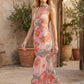 Aleena cowl neck halter maxi dress with a deep draped neckline, fitted halter strap, open back with tie-neck closure, sleeveless column silhouette, and floor-length straight hem in a smooth, elegant finish.