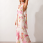 Aleena cowl neck halter maxi dress with a deep draped neckline, fitted halter strap, open back with tie-neck closure, sleeveless column silhouette, and floor-length straight hem in a smooth, elegant finish.