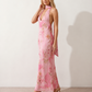 Aleena cowl neck halter maxi dress with a deep draped neckline, fitted halter strap, open back with tie-neck closure, sleeveless column silhouette, and floor-length straight hem in a smooth, elegant finish.