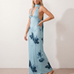 Aleena cowl neck halter maxi dress with a deep draped neckline, fitted halter strap, open back with tie-neck closure, sleeveless column silhouette, and floor-length straight hem in a smooth, elegant finish.