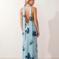 Aleena cowl neck halter maxi dress with a deep draped neckline, fitted halter strap, open back with tie-neck closure, sleeveless column silhouette, and floor-length straight hem in a smooth, elegant finish.