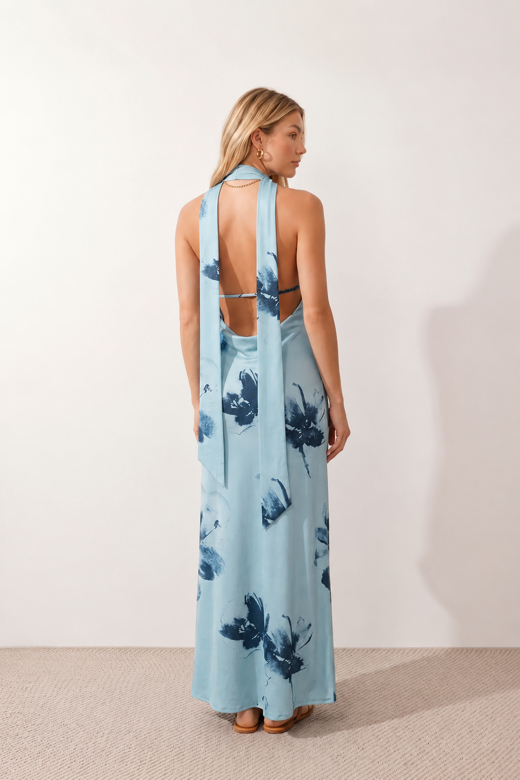 Aleena cowl neck halter maxi dress with a deep draped neckline, fitted halter strap, open back with tie-neck closure, sleeveless column silhouette, and floor-length straight hem in a smooth, elegant finish.