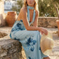 Aleena cowl neck halter maxi dress with a deep draped neckline, fitted halter strap, open back with tie-neck closure, sleeveless column silhouette, and floor-length straight hem in a smooth, elegant finish.