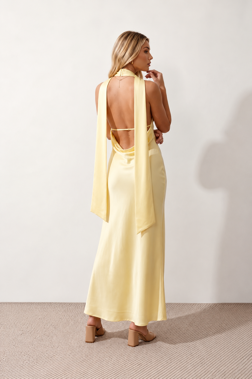 Aleena cowl neck halter maxi dress with a deep draped neckline, fitted halter strap, open back with tie-neck closure, sleeveless column silhouette, and floor-length straight hem in a smooth, elegant finish.