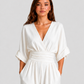 Women's deep V-neck wide-leg jumpsuit with cinched waist, relaxed rolled sleeves, lightweight flowing fabric and side pockets in an elegant silhouette.