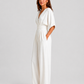 Women's deep V-neck wide-leg jumpsuit with cinched waist, relaxed rolled sleeves, lightweight flowing fabric and side pockets in an elegant silhouette.
