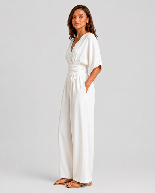 Women's deep V-neck wide-leg jumpsuit with cinched waist, relaxed rolled sleeves, lightweight flowing fabric and side pockets in an elegant silhouette.