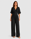 Women's deep V-neck wide-leg jumpsuit with cinched waist, relaxed rolled sleeves, lightweight flowing fabric and side pockets in an elegant silhouette.