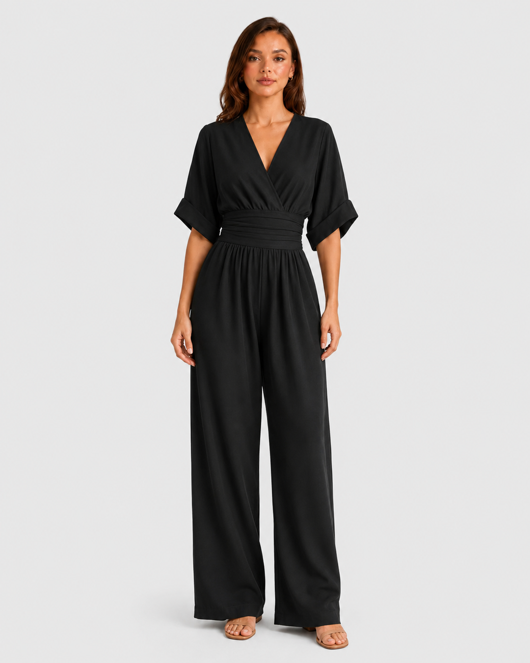 Women's deep V-neck wide-leg jumpsuit with cinched waist, relaxed rolled sleeves, lightweight flowing fabric and side pockets in an elegant silhouette.