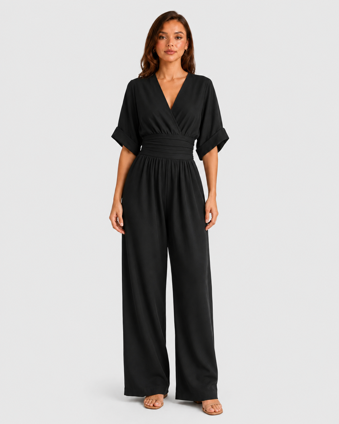 Women's deep V-neck wide-leg jumpsuit with cinched waist, relaxed rolled sleeves, lightweight flowing fabric and side pockets in an elegant silhouette.