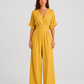 Women's deep V-neck wide-leg jumpsuit with cinched waist, relaxed rolled sleeves, lightweight flowing fabric and side pockets in an elegant silhouette.