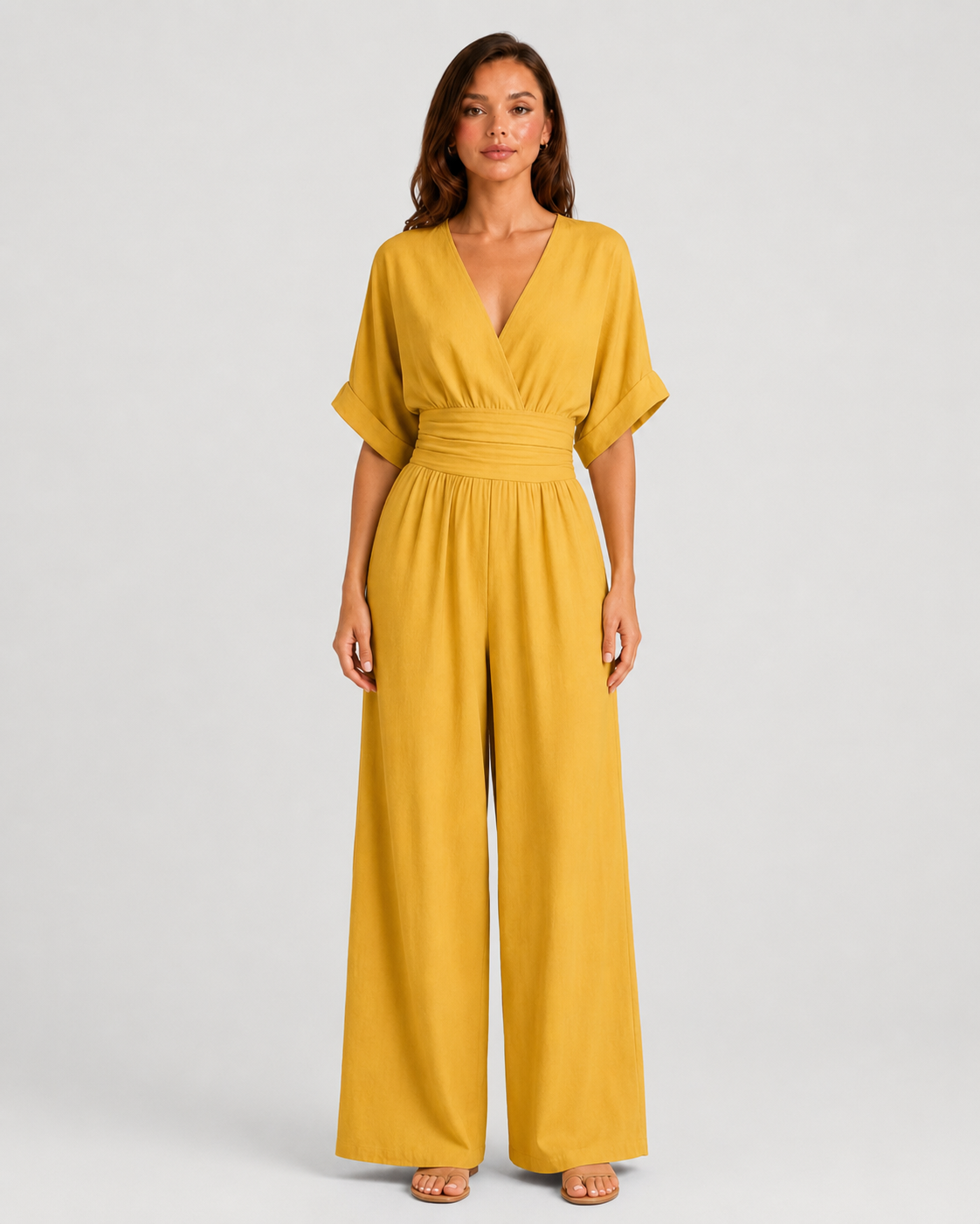 Women's deep V-neck wide-leg jumpsuit with cinched waist, relaxed rolled sleeves, lightweight flowing fabric and side pockets in an elegant silhouette.