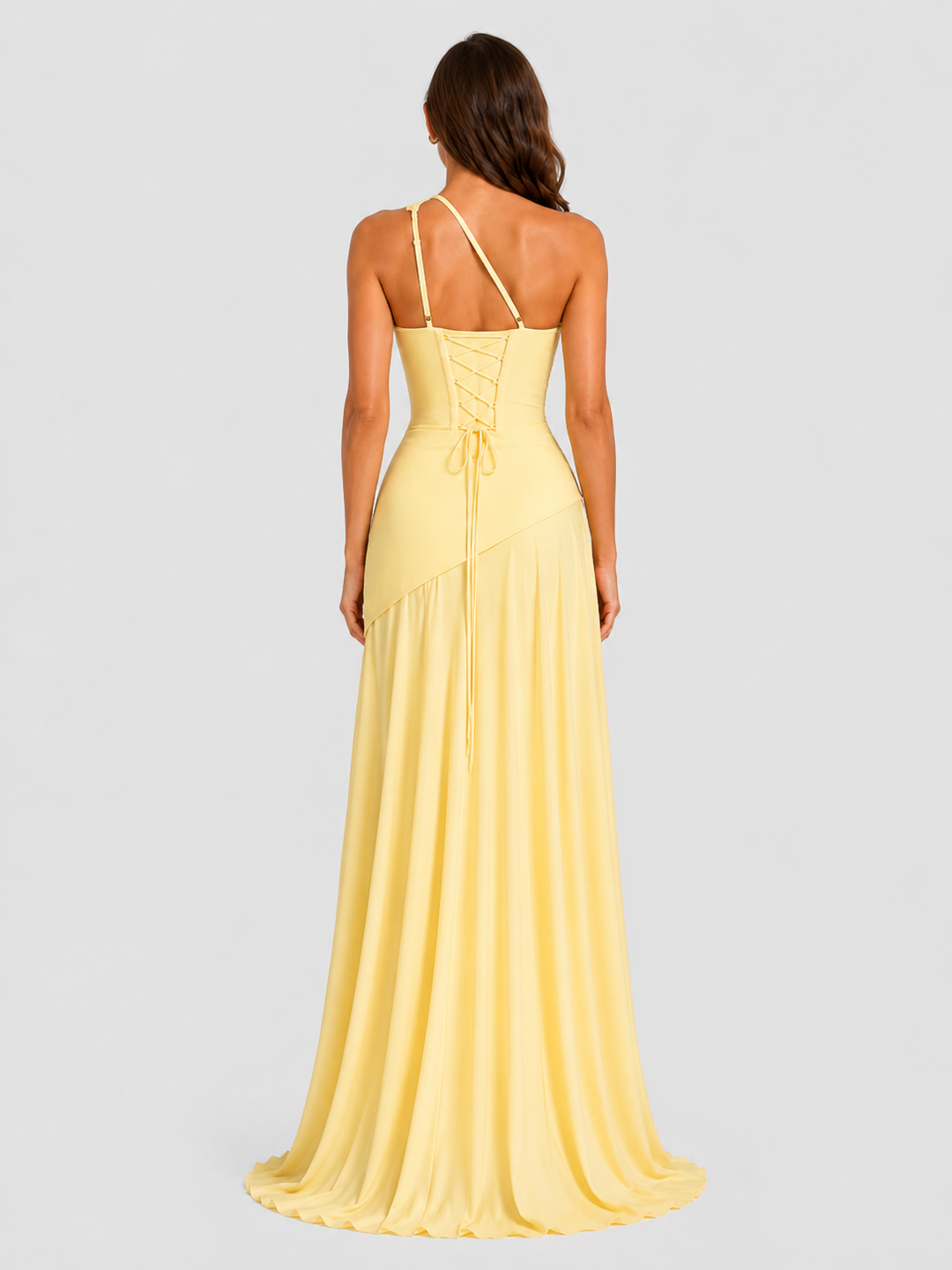 Woman wearing a one-shoulder chiffon maxi dress featuring a pleated neckline, corset bodice with lace-up back, and flowing godet skirt in an elegant formal silhouette.