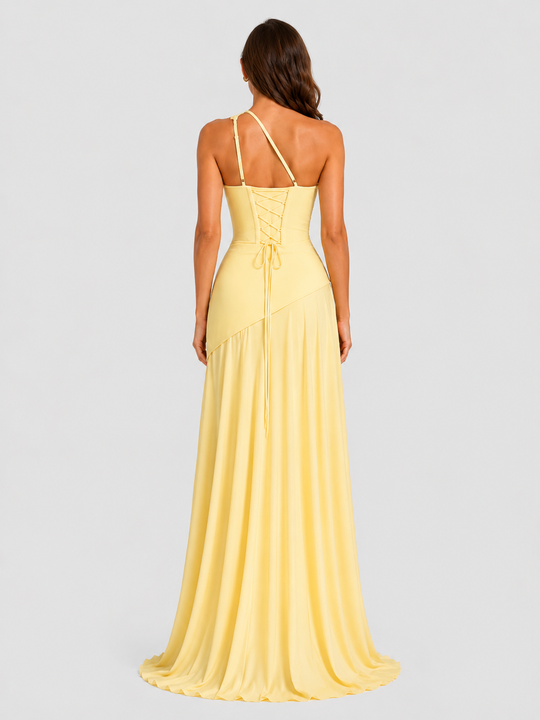 Woman wearing a one-shoulder chiffon maxi dress featuring a pleated neckline, corset bodice with lace-up back, and flowing godet skirt in an elegant formal silhouette.