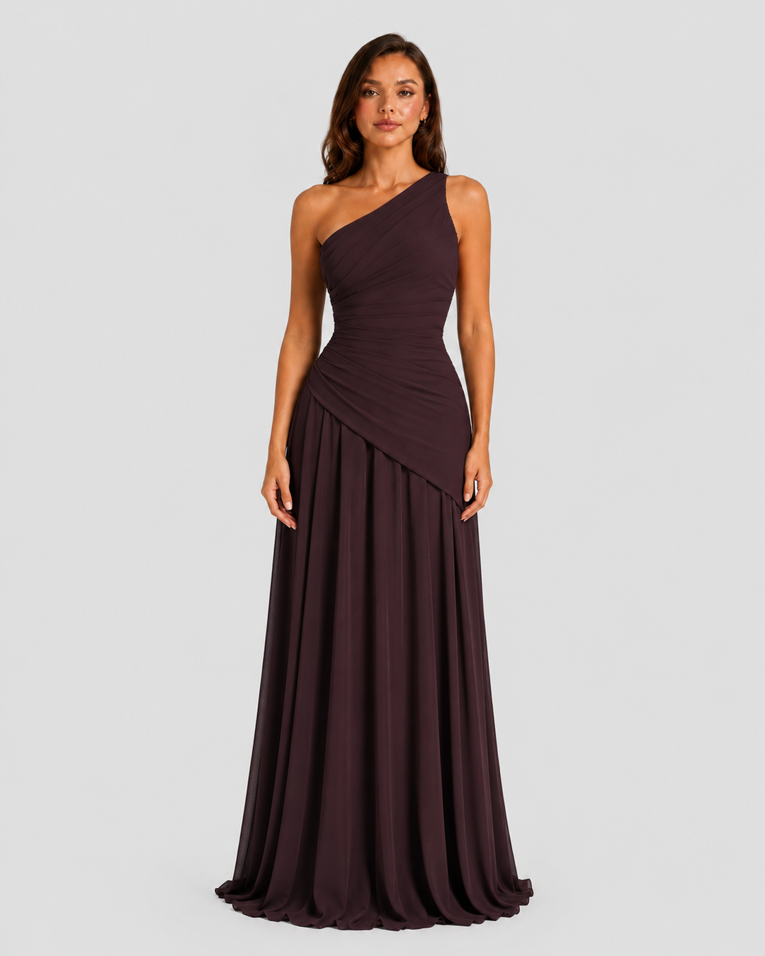 Woman wearing a one-shoulder chiffon maxi dress featuring a pleated neckline, corset bodice with lace-up back, and flowing godet skirt in an elegant formal silhouette.