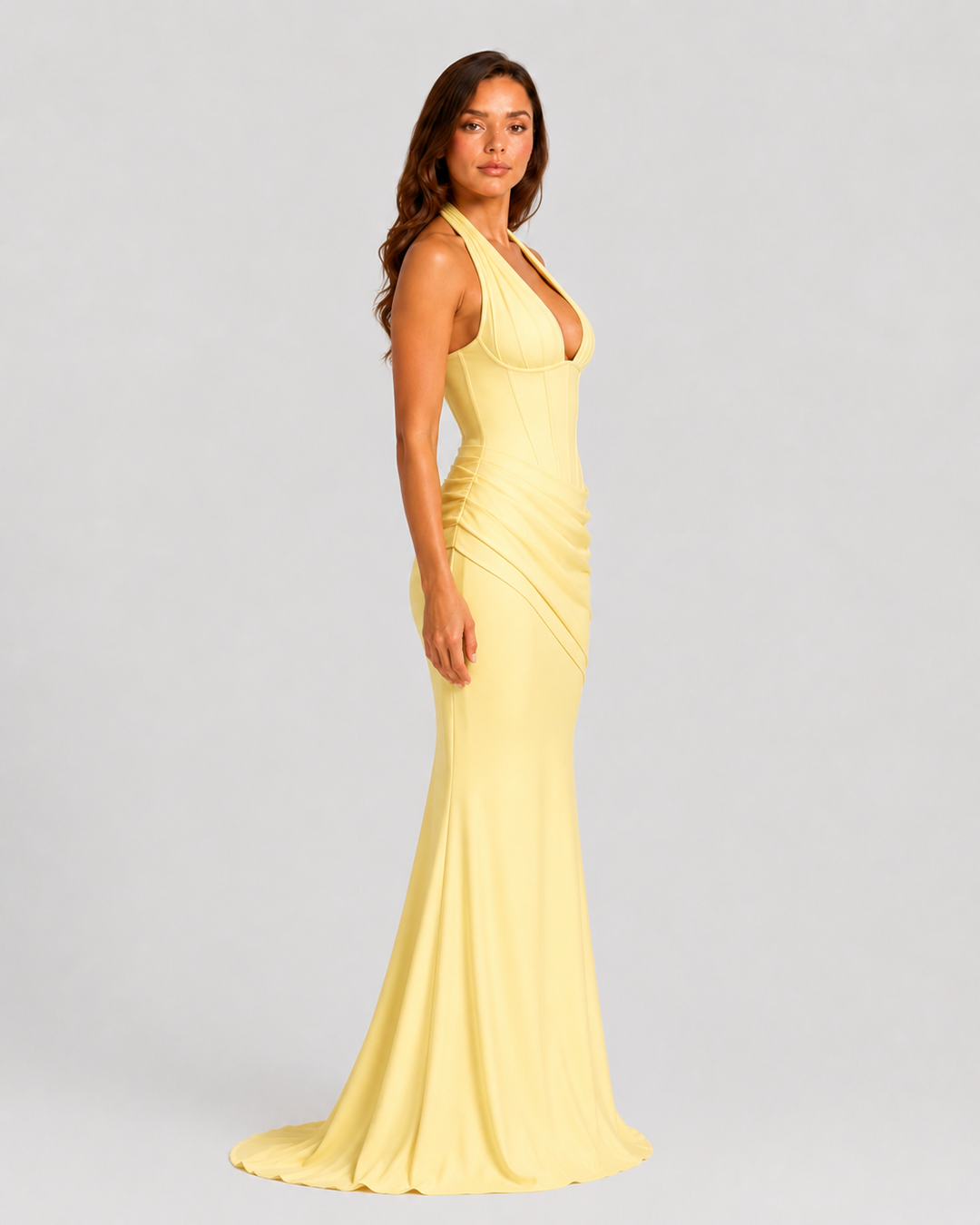 Women's halter corset evening gown featuring a plunge neckline, structured boned bodice, asymmetric pleated draped skirt detail, lace-up back, and softly flared crepe silhouette.