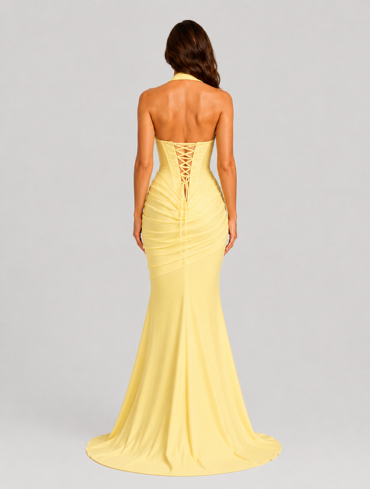 Women's halter corset evening gown featuring a plunge neckline, structured boned bodice, asymmetric pleated draped skirt detail, lace-up back, and softly flared crepe silhouette.