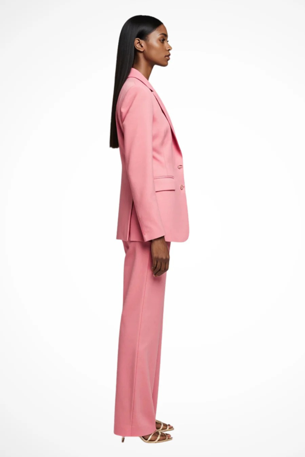 Woman wearing a pink suit standing against a white background