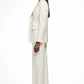 Woman wearing a white suit standing against a white background
